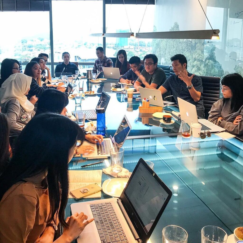LOKi specialists in a collaborative strategy workshop discussing campaigns, digital performance, and creative planning during a team meeting.